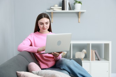 Photo of Young woman working on laptop at home