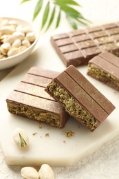 Pieces of delicious Dubai chocolate with pistachios and knafeh on table, closeup