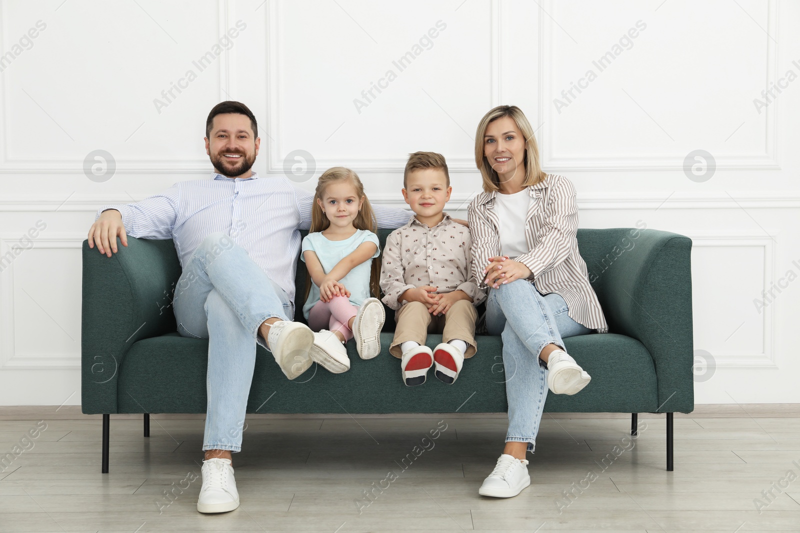 Photo of Happy parents and their children on sofa at home