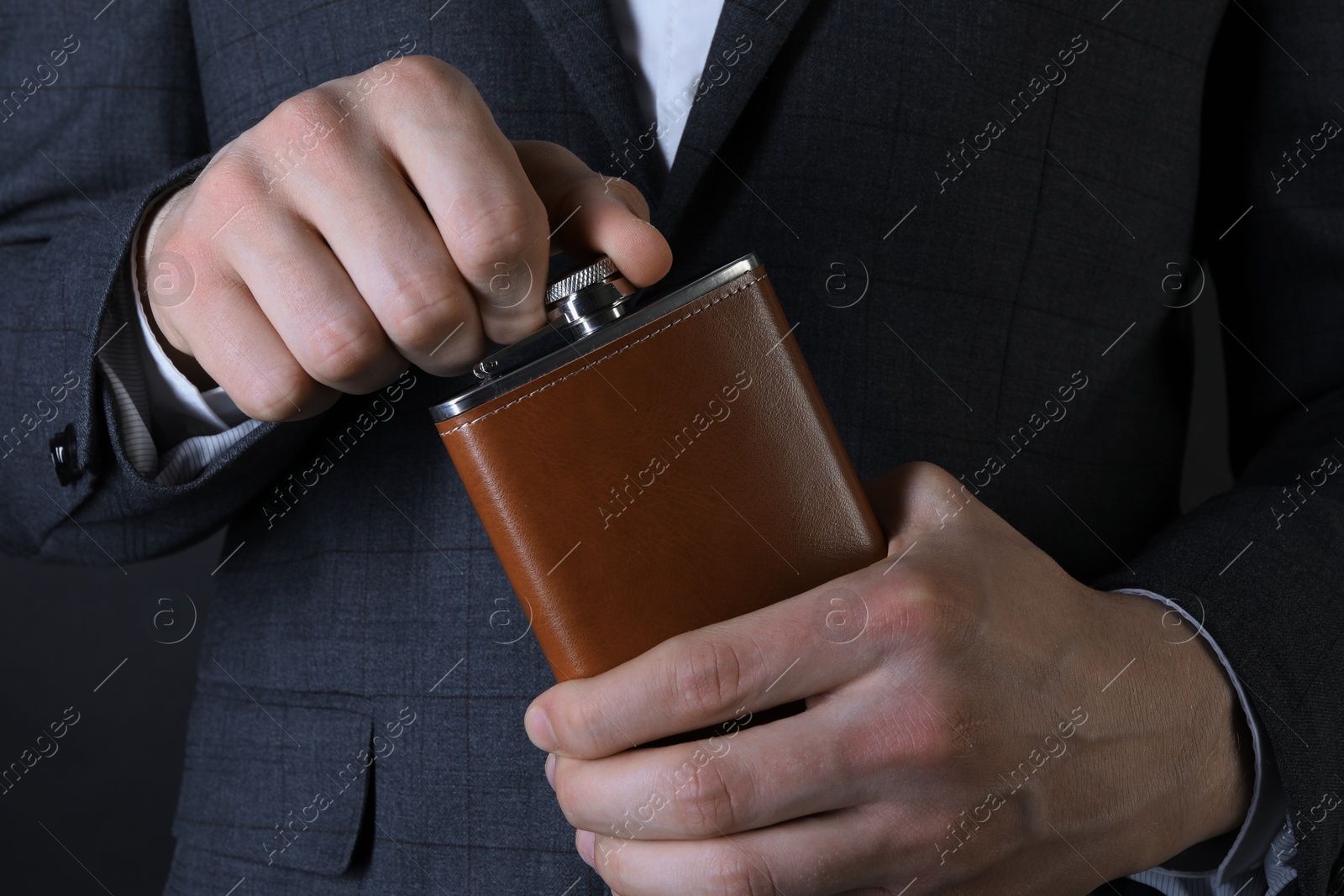 Photo of Man in suit holding new hip flask, closeup view