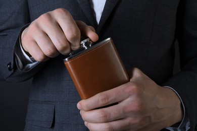 Photo of Man in suit holding new hip flask, closeup view