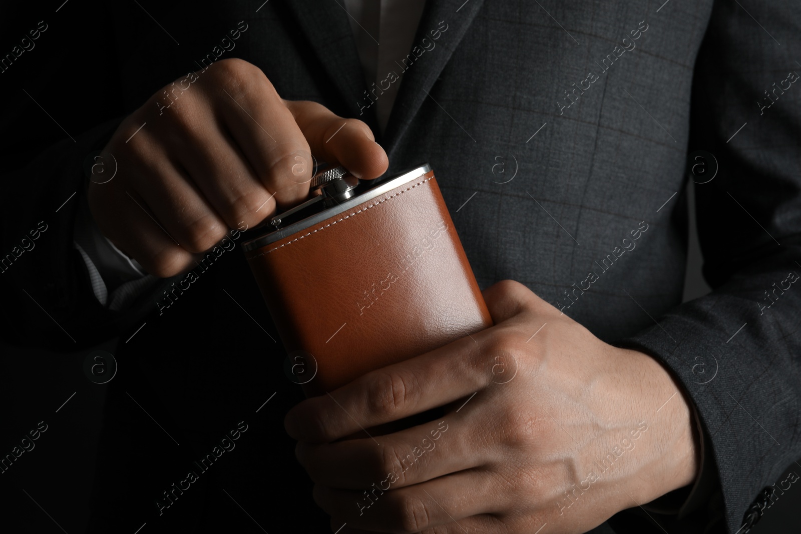 Photo of Man in suit holding new hip flask, closeup view