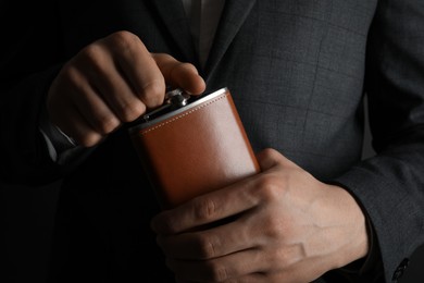 Photo of Man in suit holding new hip flask, closeup view