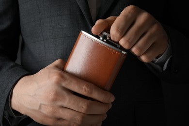 Photo of Man in suit holding new hip flask, closeup view