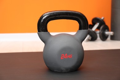 Photo of One kettlebell on mat indoors, closeup. Sport equipment