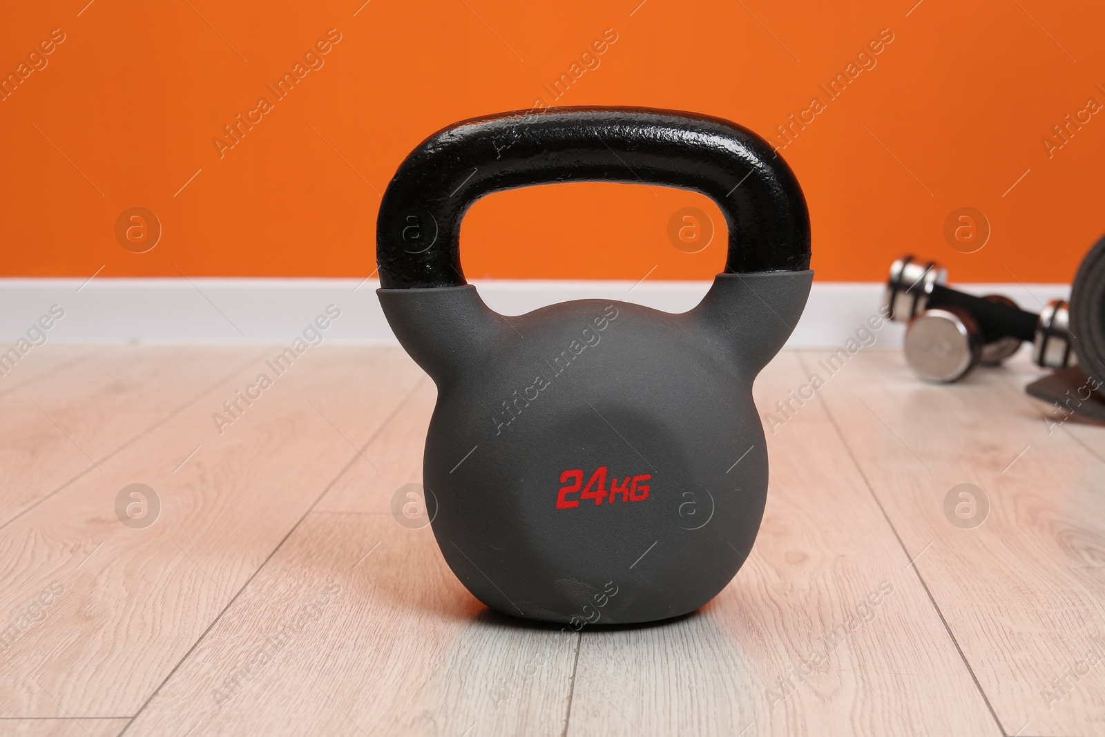 Photo of One kettlebell on floor indoors, closeup. Sport equipment