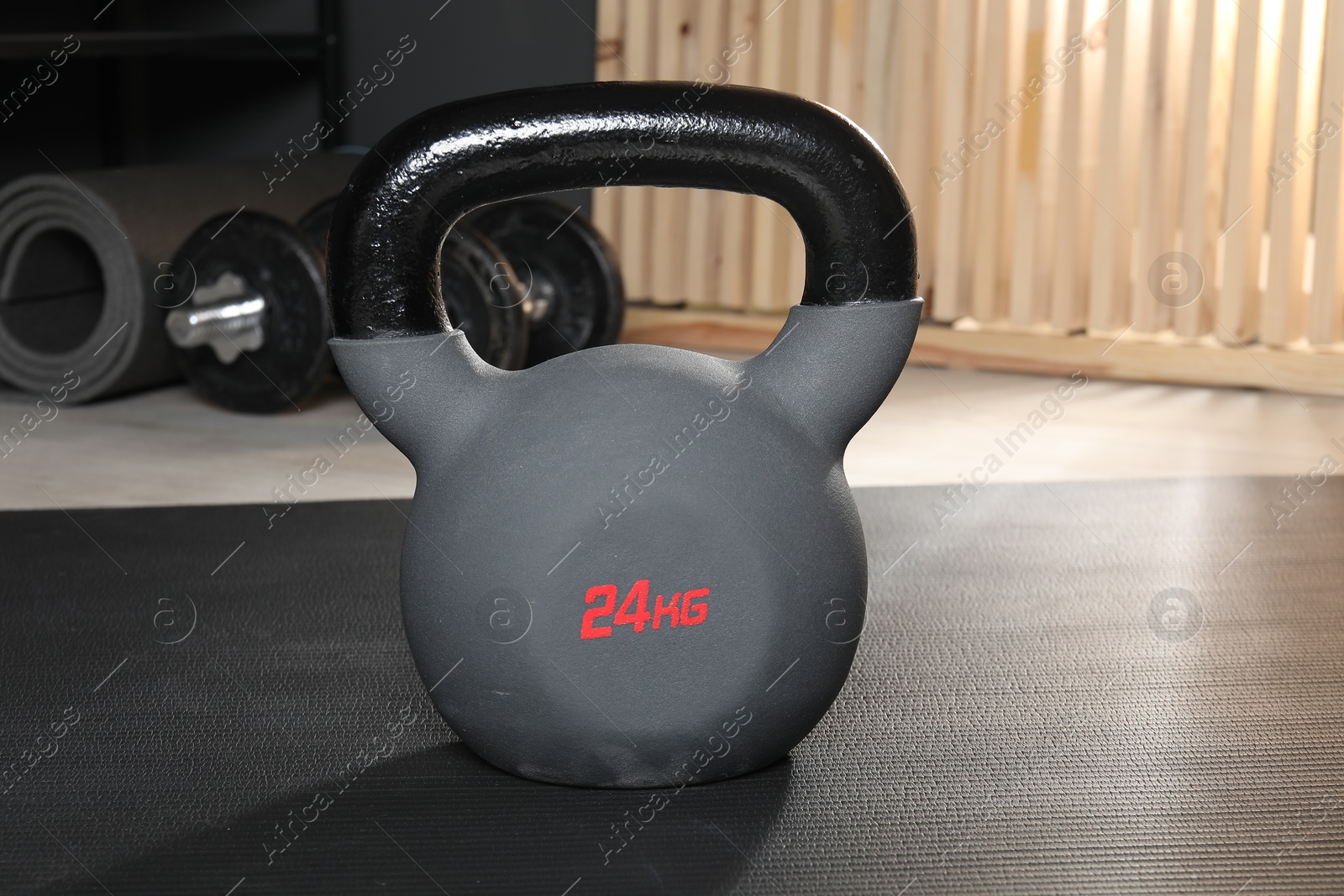 Photo of One kettlebell on mat in gym, closeup