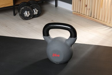 Photo of One kettlebell and mat on floor in gym