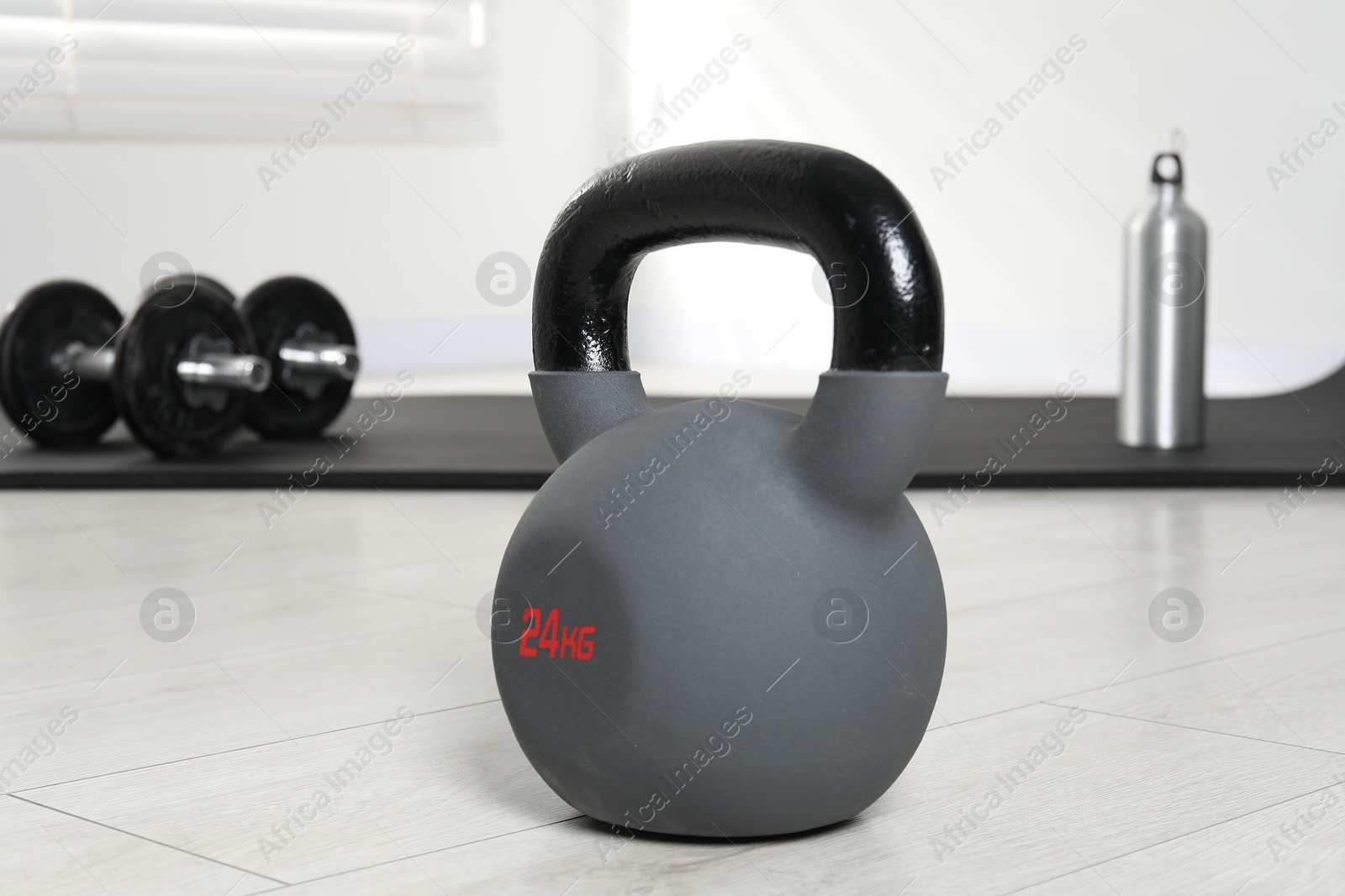 Photo of One heavy kettlebell on floor indoors, closeup