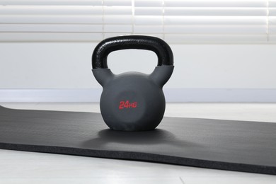 Photo of One kettlebell and mat on floor indoors