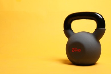 Photo of One heavy kettlebell on yellow background. Space for text