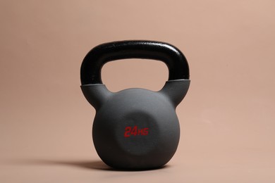 Photo of One heavy kettlebell on beige background. Sport equipment