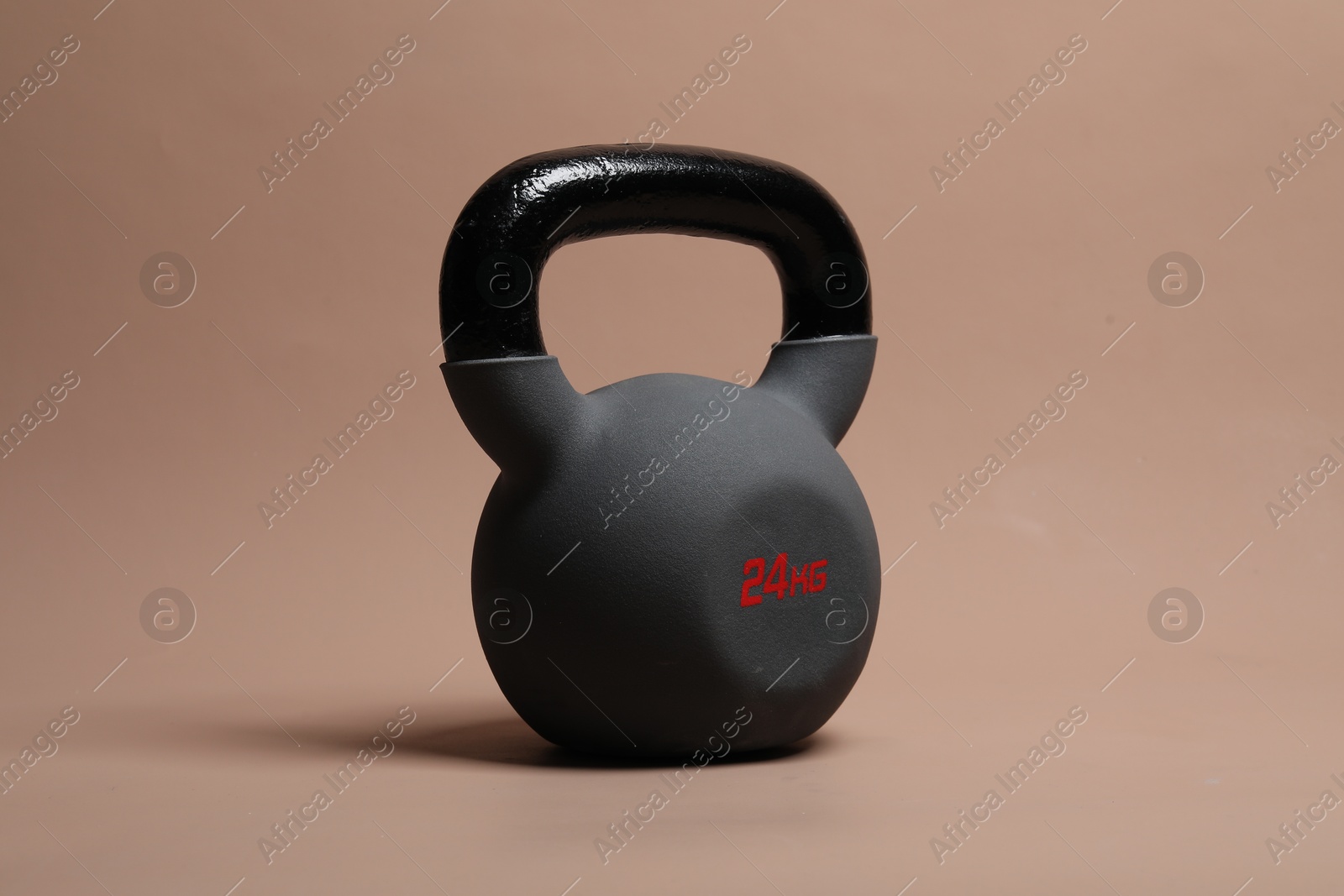 Photo of One heavy kettlebell on beige background. Sport equipment