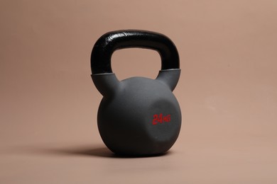 Photo of One heavy kettlebell on beige background. Sport equipment