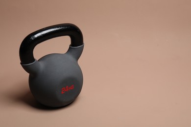 Photo of One heavy kettlebell on beige background. Space for text