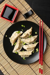 Photo of Delicious gyoza dumplings with chives served on table, top view