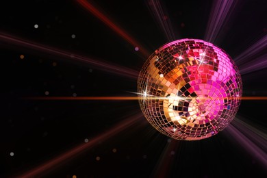 Image of Disco ball reflecting light on black background. Nightclub decor