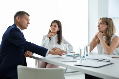 Photo of Office employees talking at table during meeting