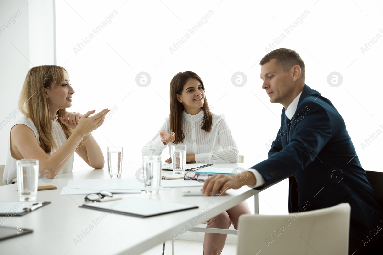 Photo of Office employees talking at table during meeting