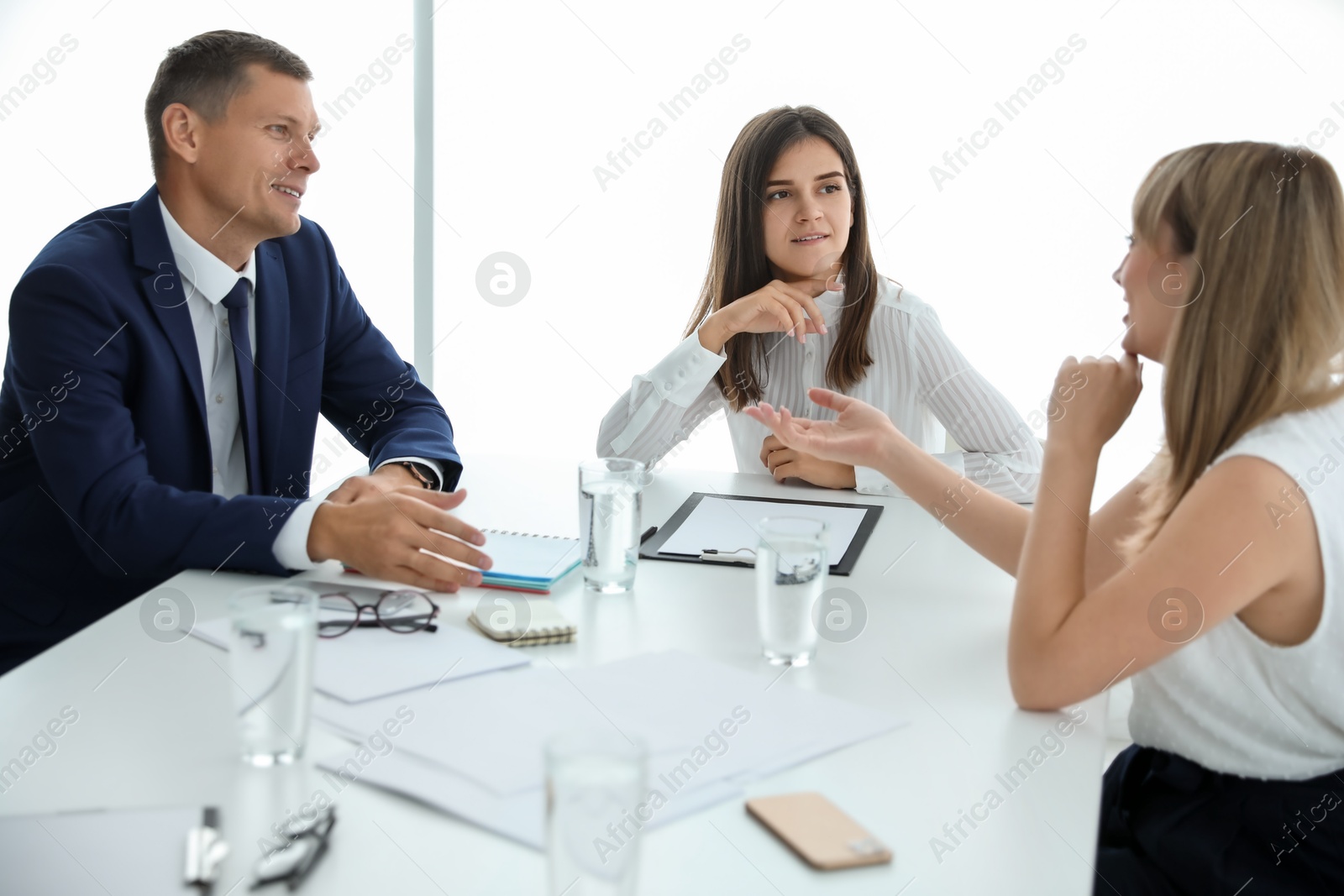 Photo of Office employees talking at table during meeting