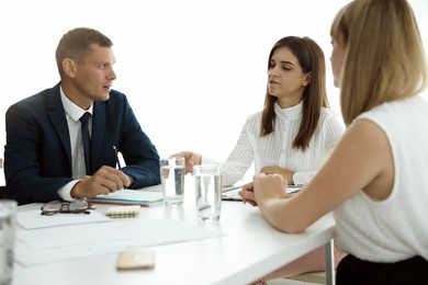 Photo of Office employees talking at table during meeting