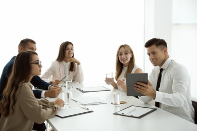 Photo of Office employees talking at table during meeting