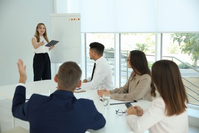 Female business coach talking to audience in office