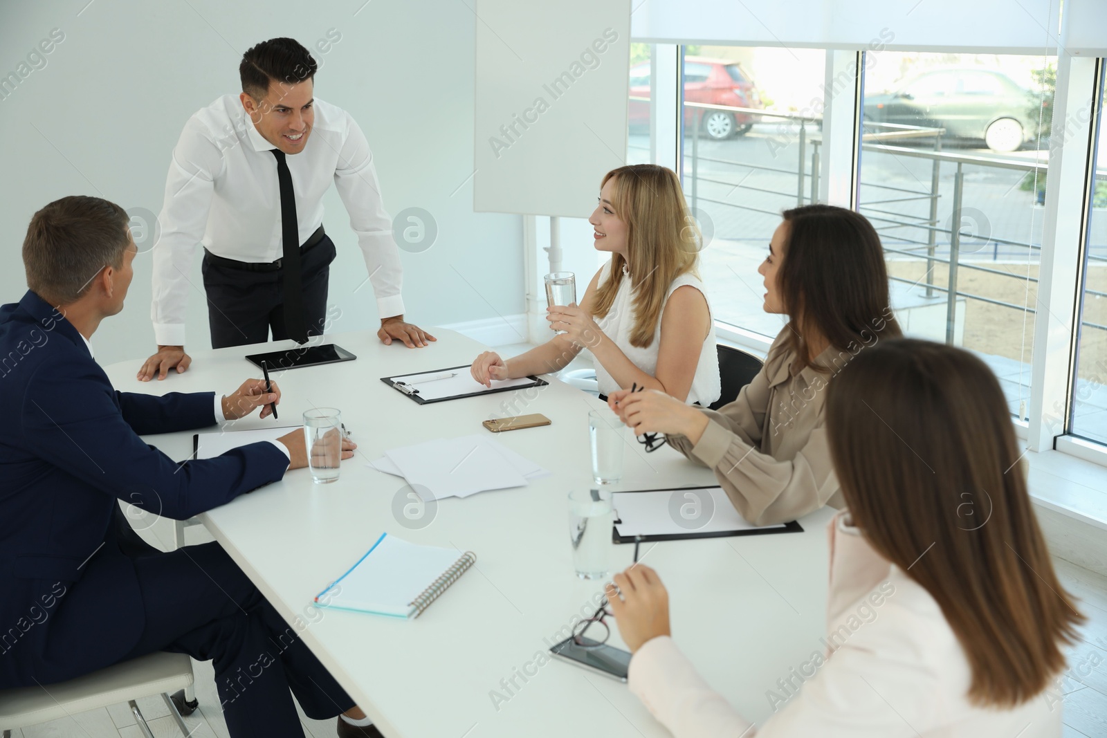 Photo of Office employees talking at table during meeting