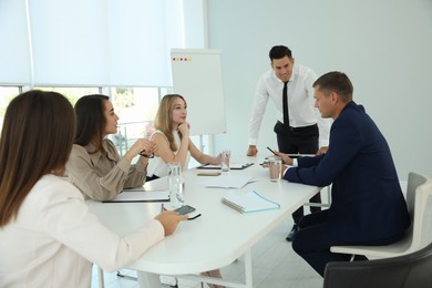 Office employees talking at table during meeting