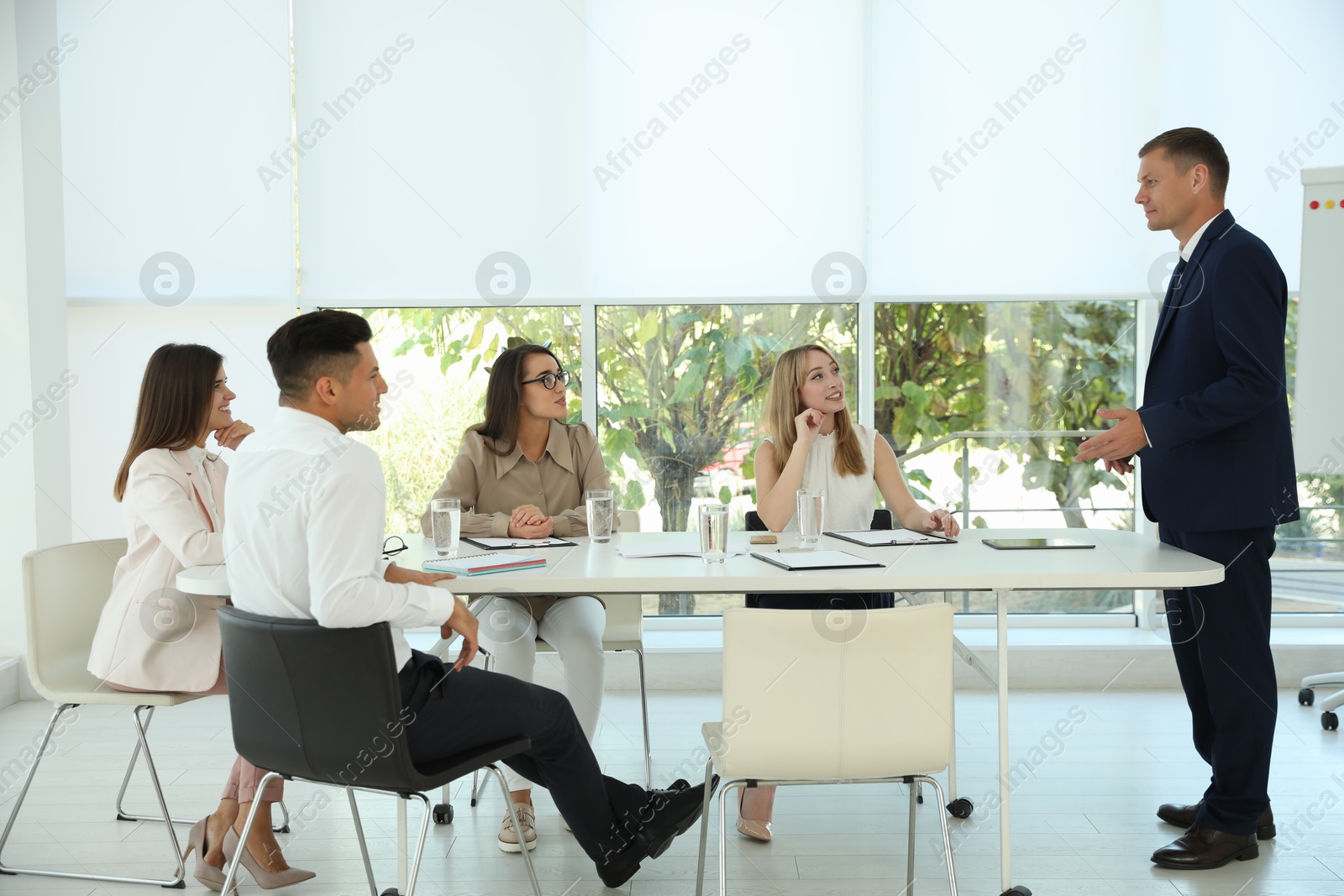 Photo of Male business coach talking to audience in office