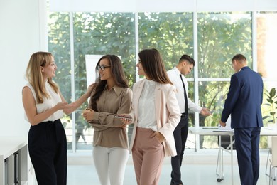 Office employees talking at workplace during break