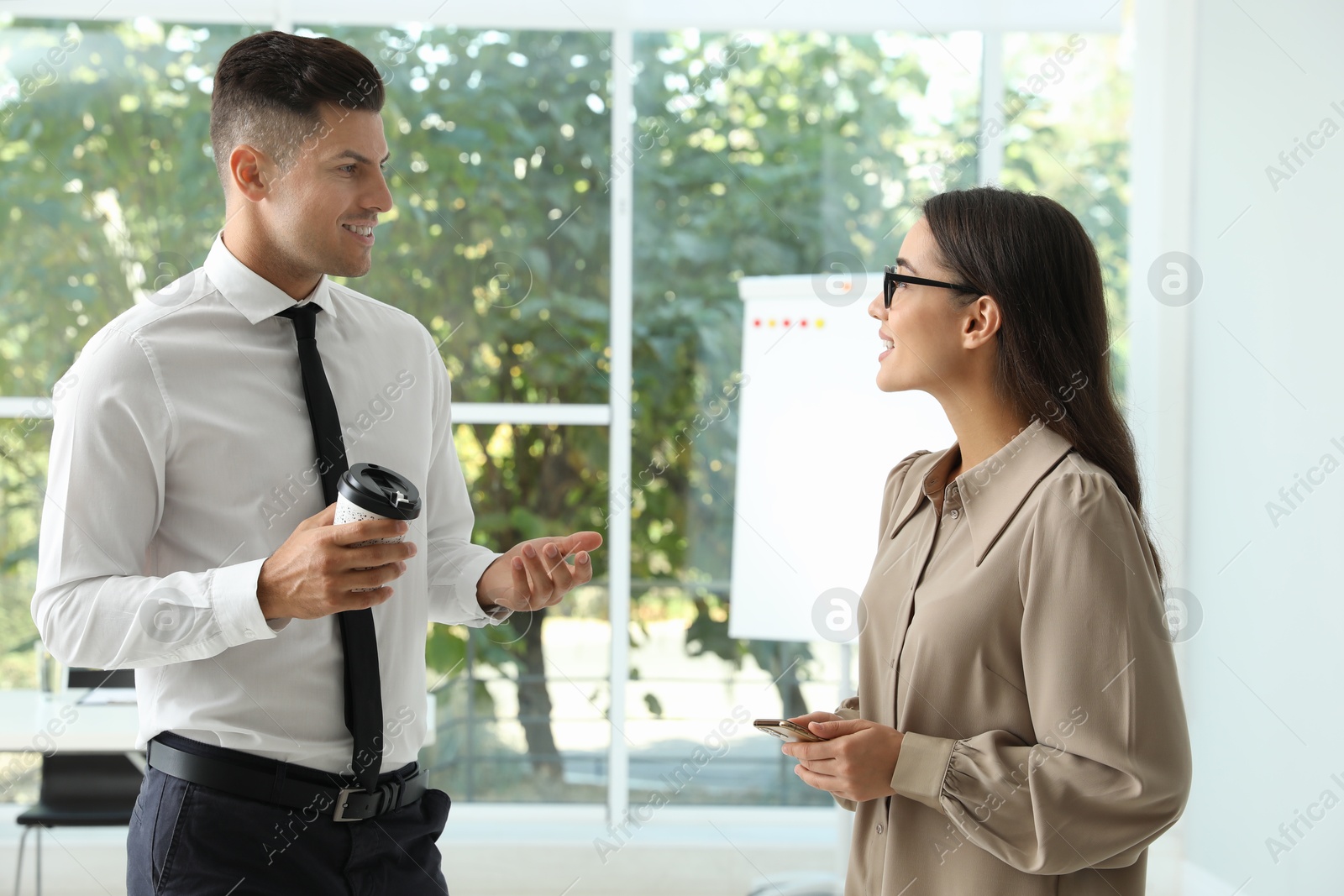 Photo of Office employees talking at workplace during break