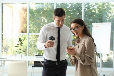 Photo of Office employees talking at workplace during break