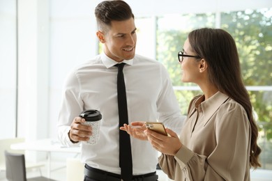 Office employees talking at workplace during break