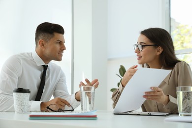 Office employees talking at table during meeting