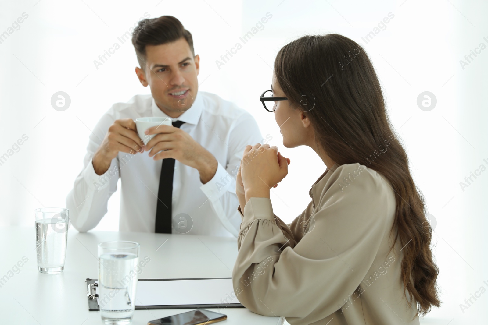 Photo of Office employees talking at table during meeting