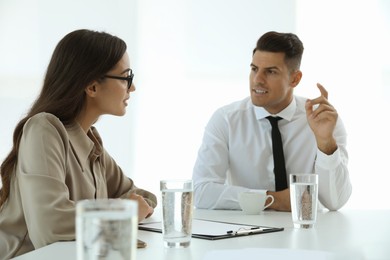 Office employees talking at table during meeting