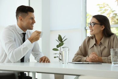 Photo of Office employees talking at table during meeting