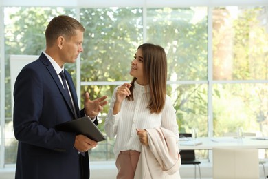 Photo of Office employees talking at workplace during break