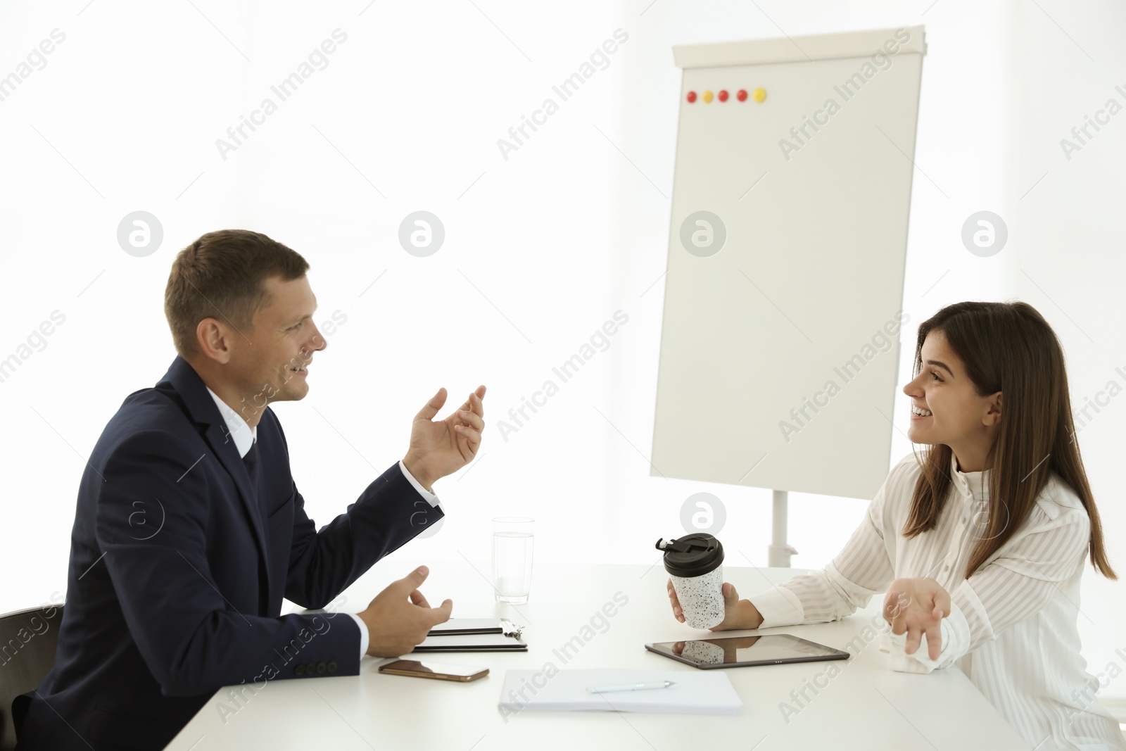 Photo of Office employees talking at table during meeting