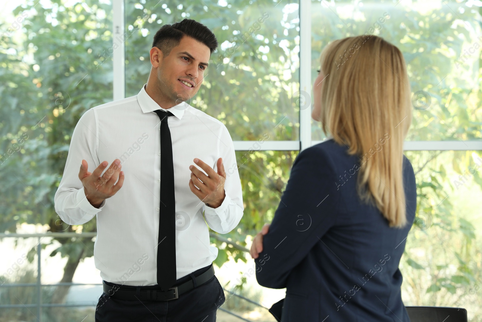 Photo of Office employees talking at workplace during break