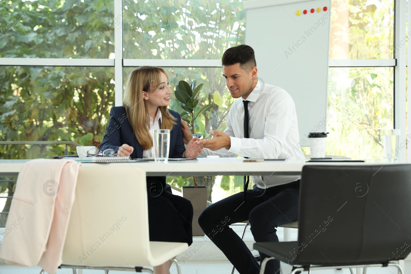 Photo of Office employees talking at table during meeting