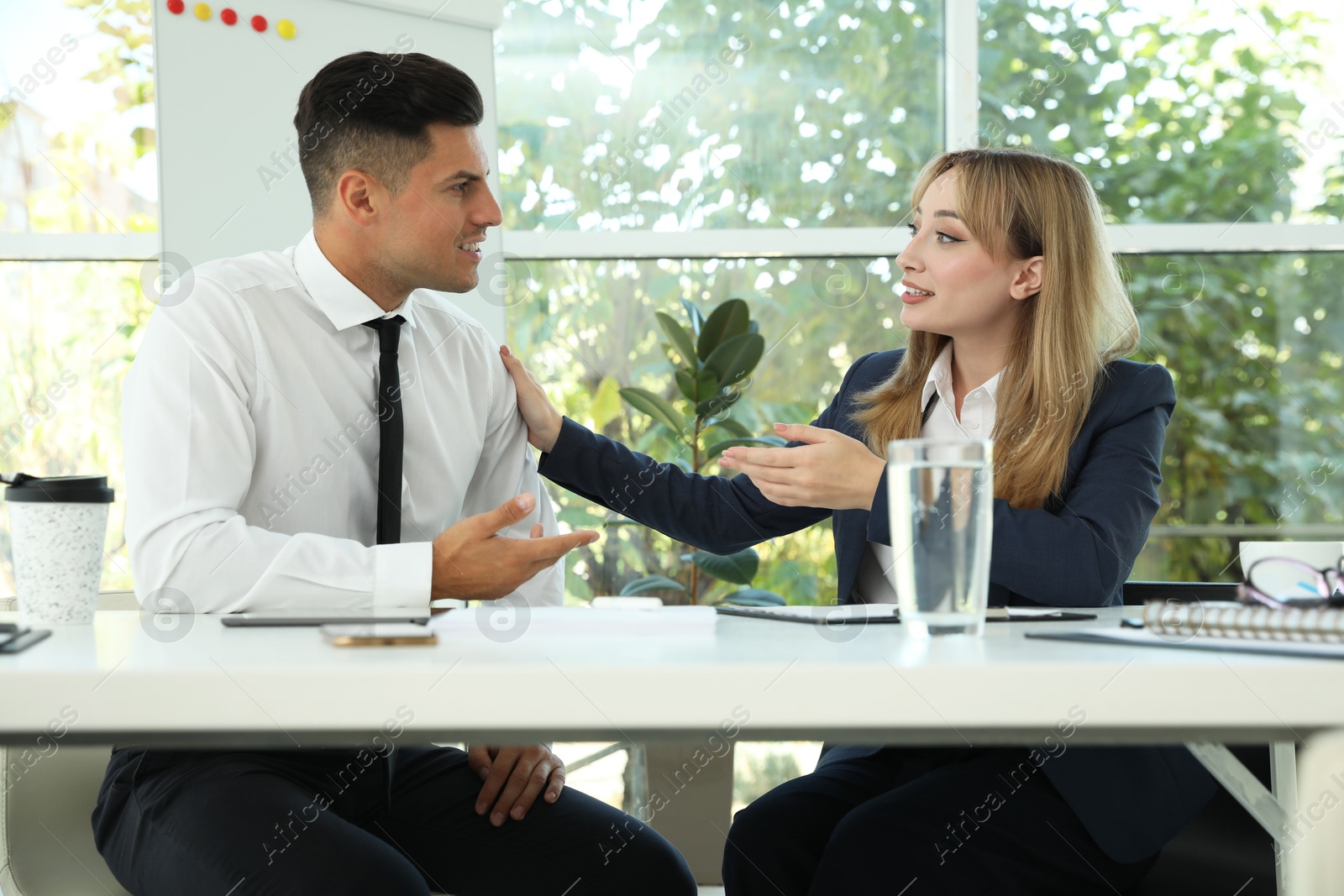 Photo of Office employees talking at table during meeting