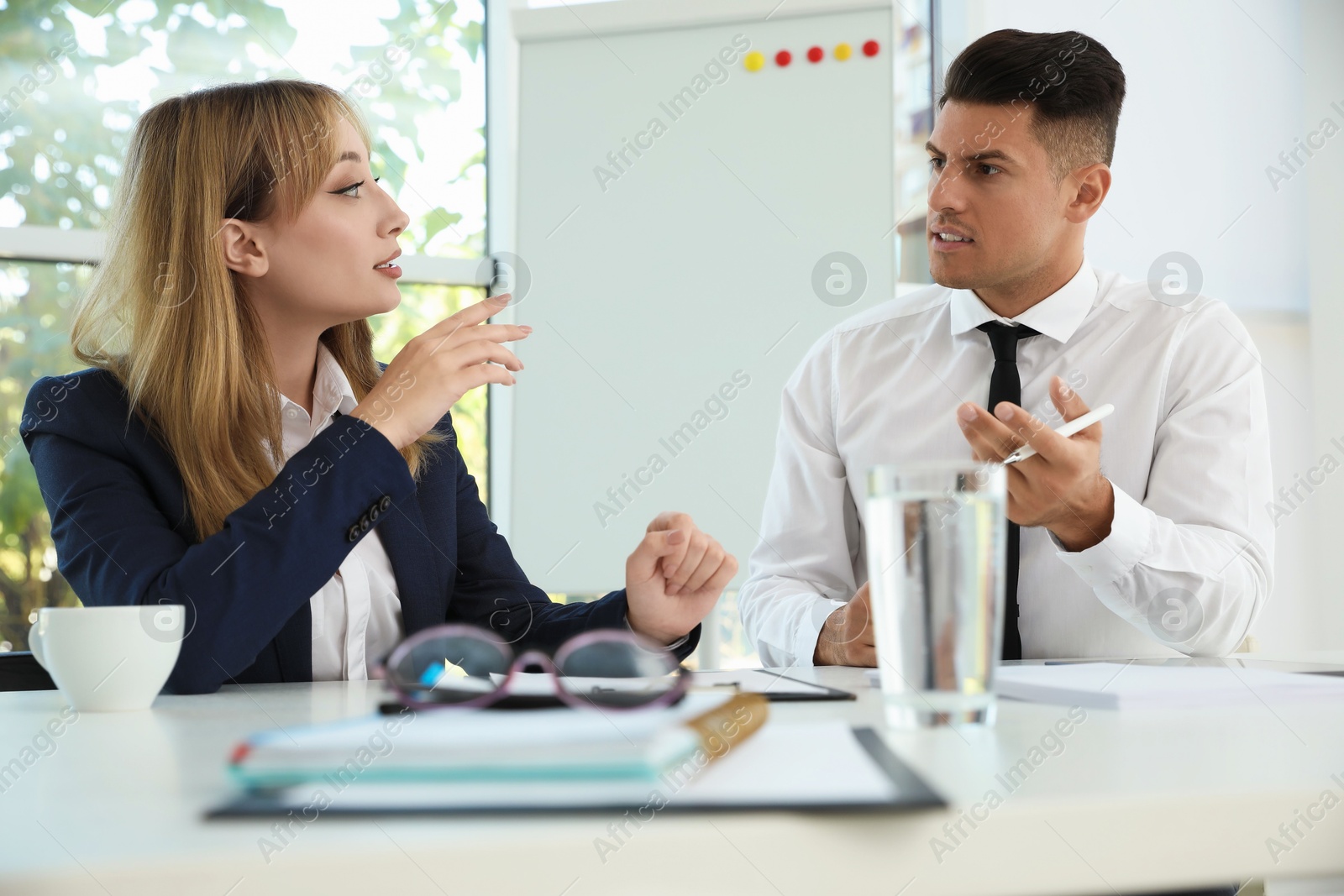 Photo of Office employees talking at table during meeting