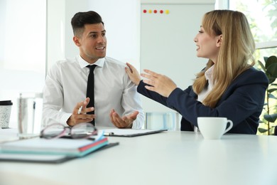 Photo of Office employees talking at table during meeting