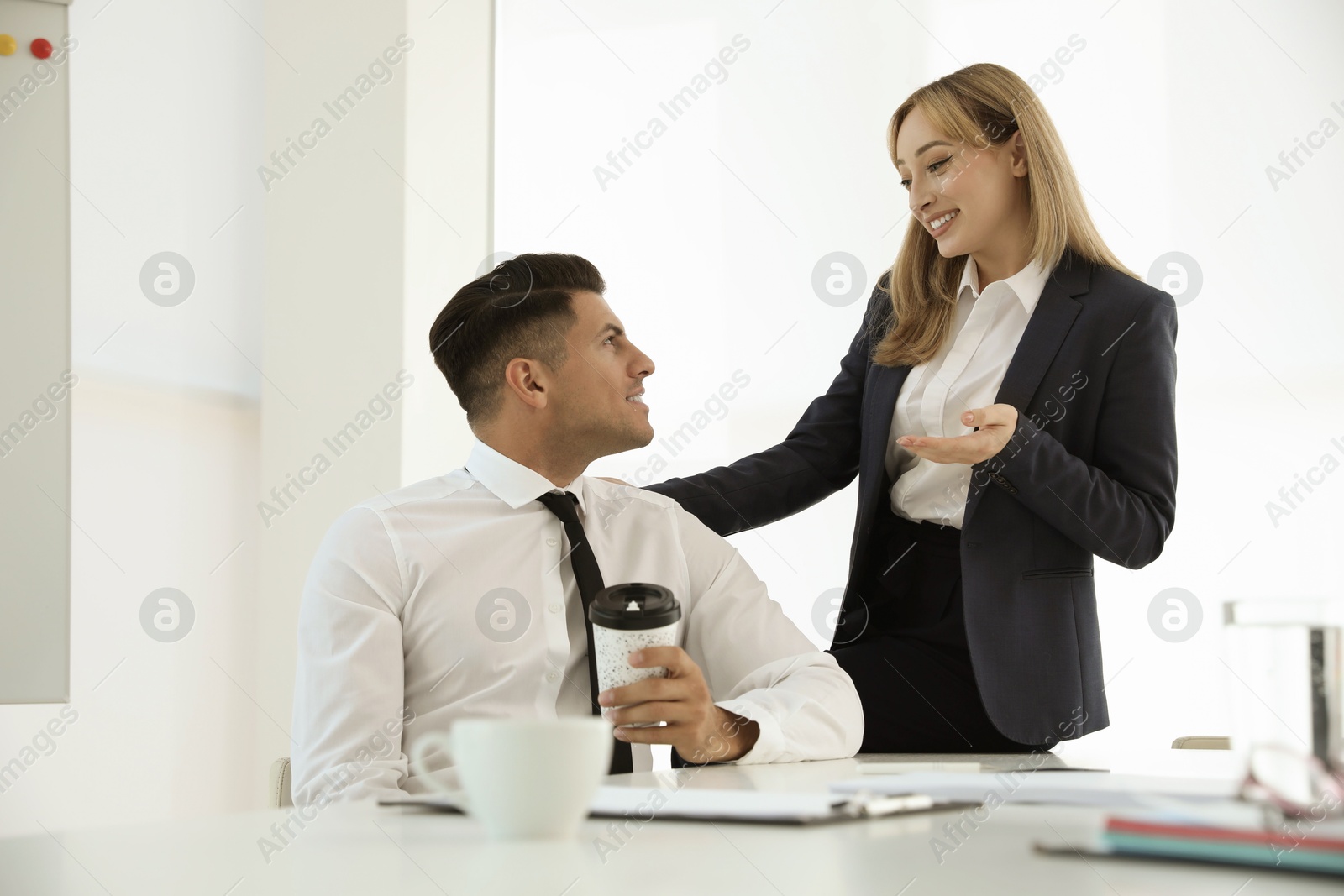 Photo of Office employees talking at workplace during break