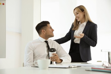 Office employees talking at workplace during break