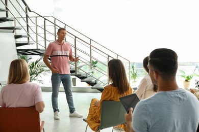 Male lecturer in casual clothes talking to audience indoors