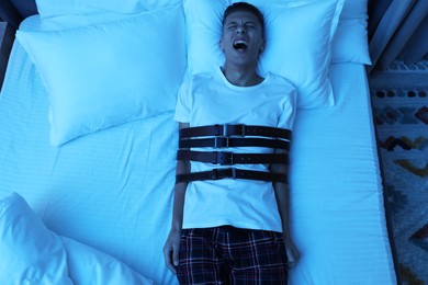 Photo of Man in sleepwalking condition screaming on bed, above view