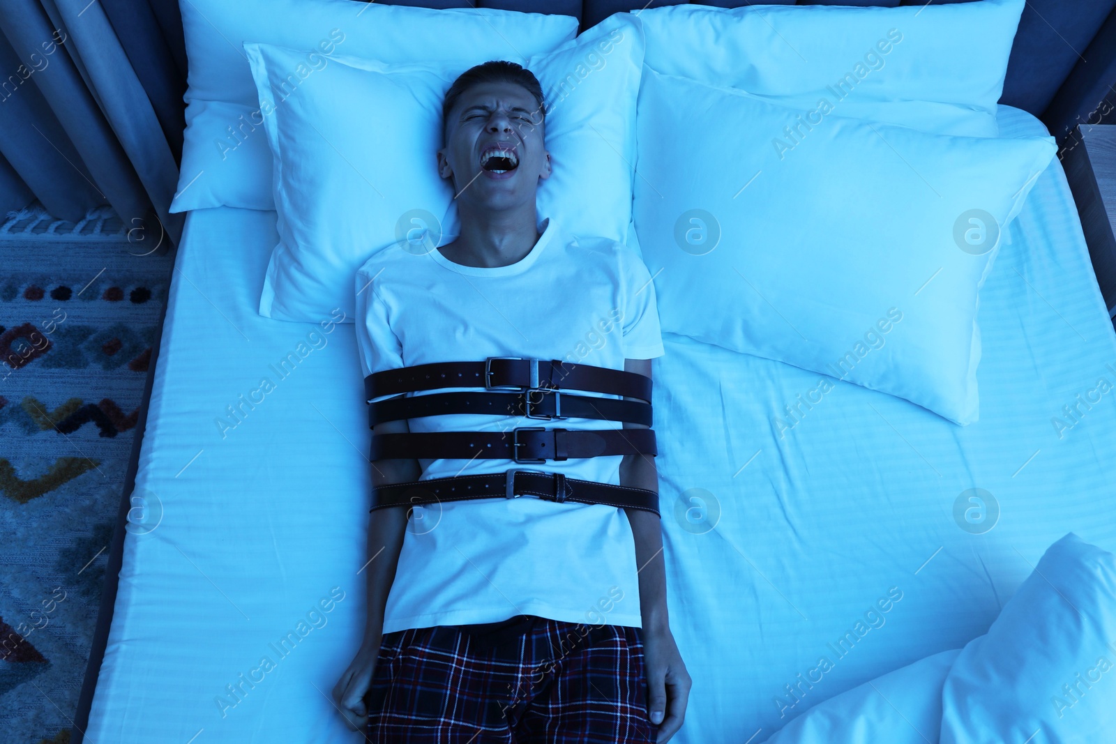 Photo of Man in sleepwalking condition screaming on bed, above view